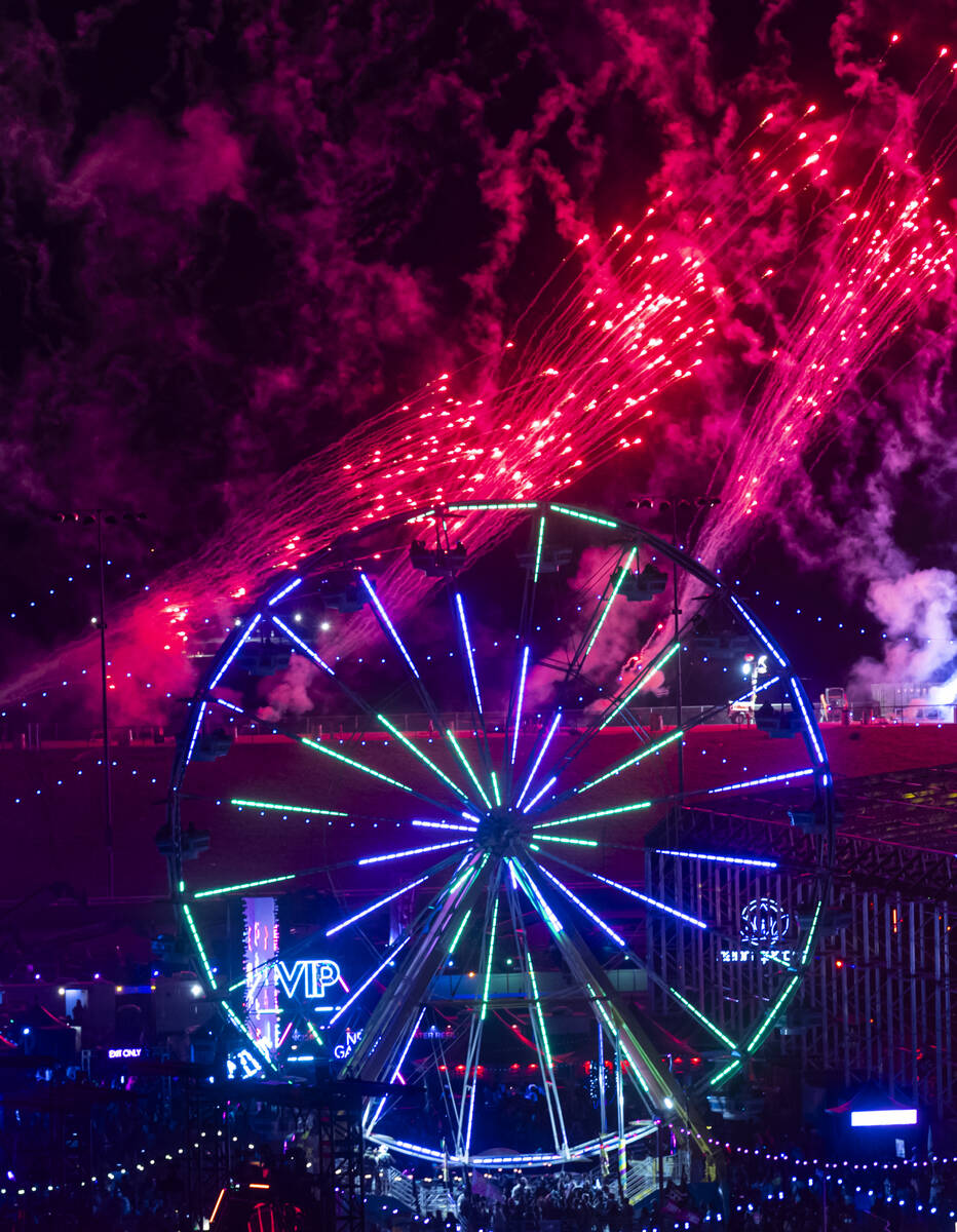 Fireworks go off as festivalgoers ride a ferris wheel during the second night of the Electric D ...