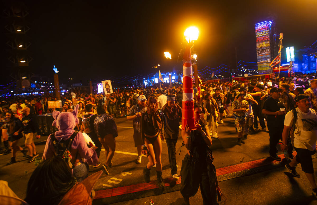 An attendee passes by with a construction cone as a totem during the second night of the Electr ...