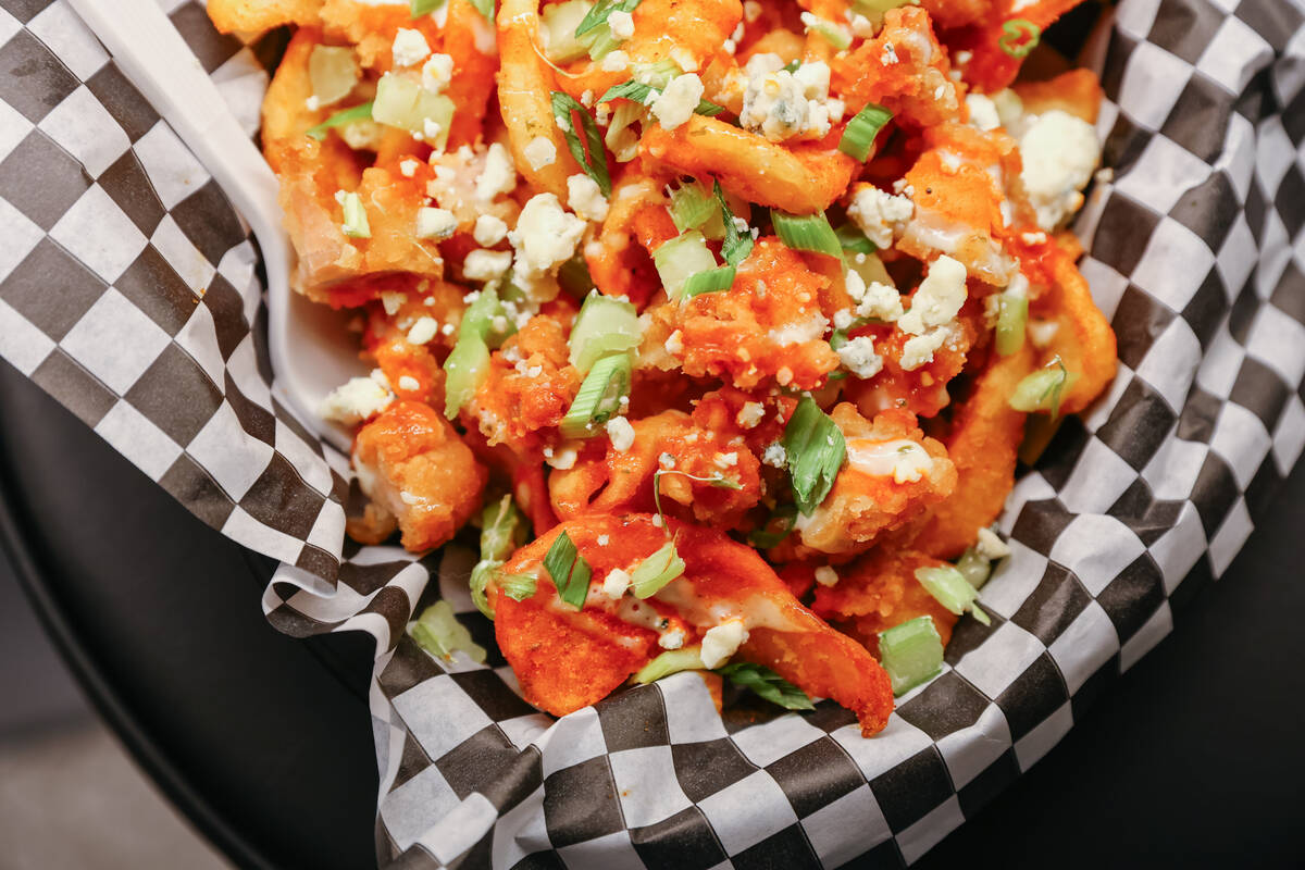 The buffalo chicken fries, with fried chicken, buffalo sauce, blue cheese crumbles, diced celer ...