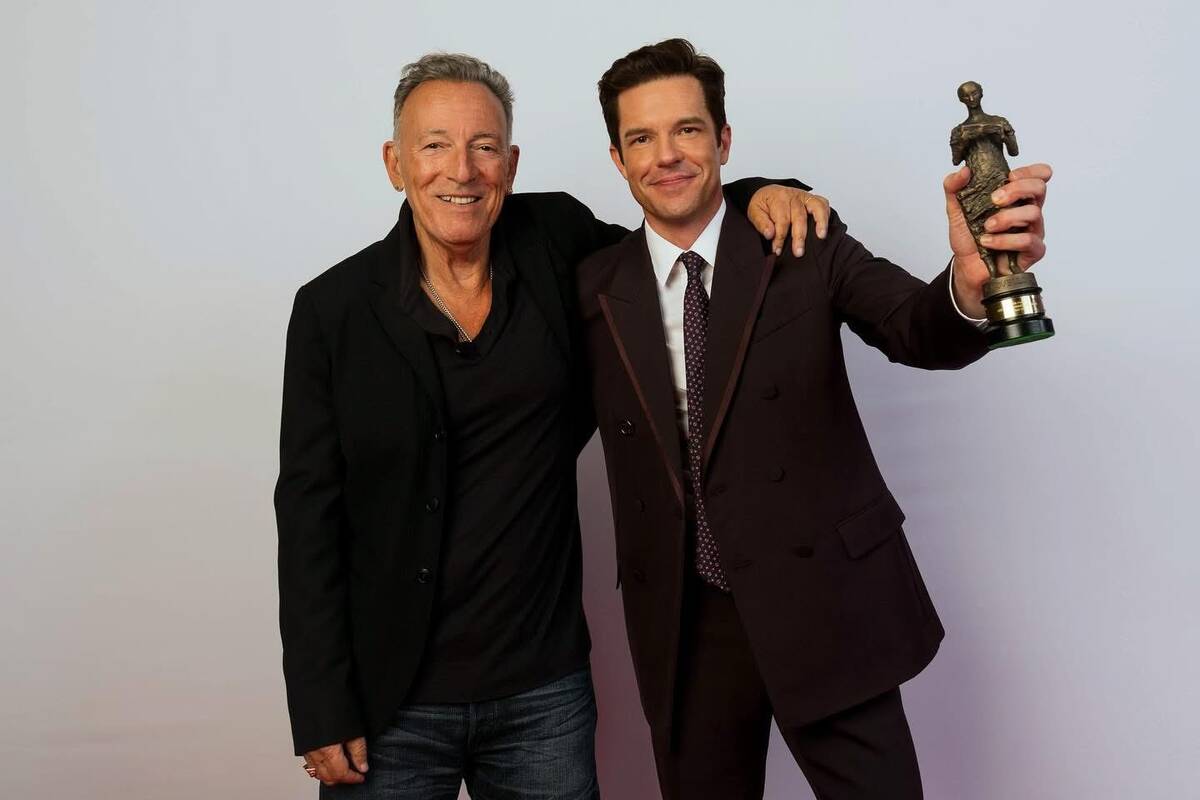 Bruce Springsteen is shown with Brandon Blowers after presenting the Killers' frontman with the ...