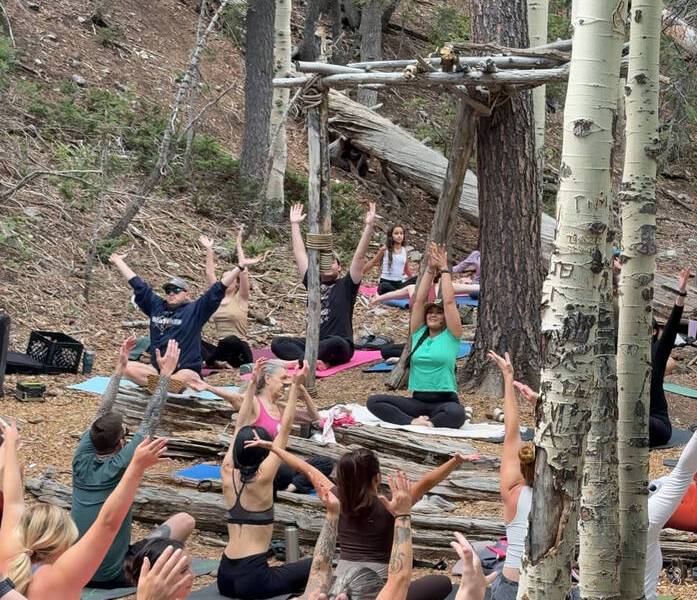 An outdoor yoga class is held in the quaking aspen grove of Lee Canyon on Sunday, June 8, 2025. ...