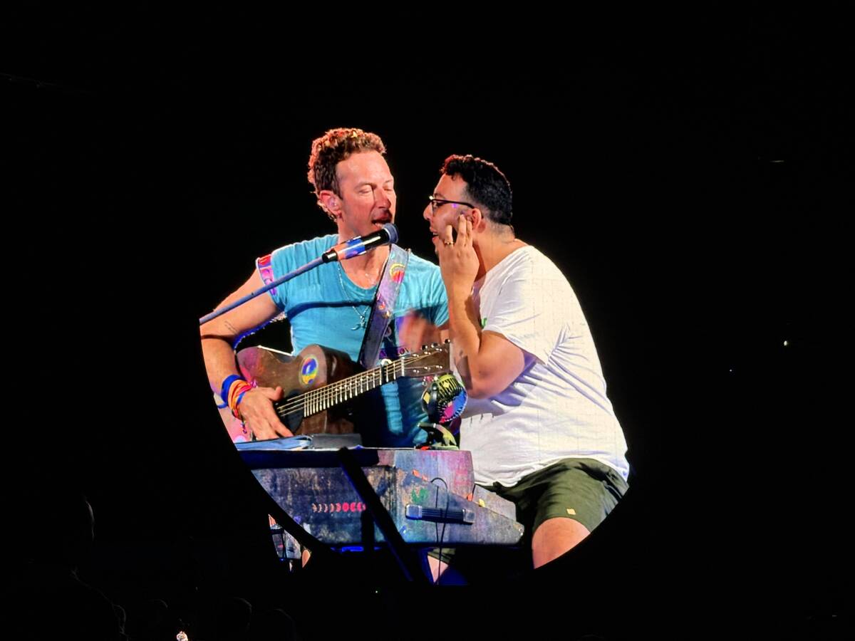 Chris Martin of Coldplay and a fan are shown during the "Music of the Spheres" tour stop at All ...