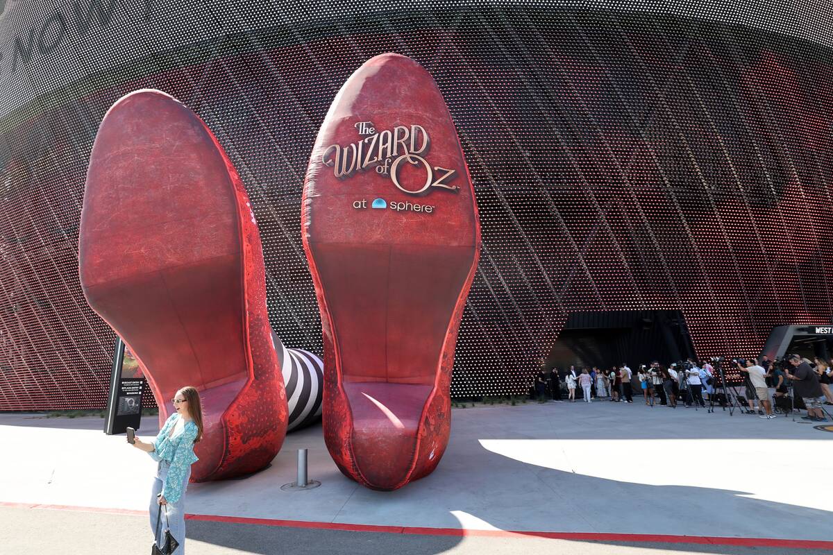 People check out the Wicked Witch of the East legs and ruby slippers installation promoting &qu ...