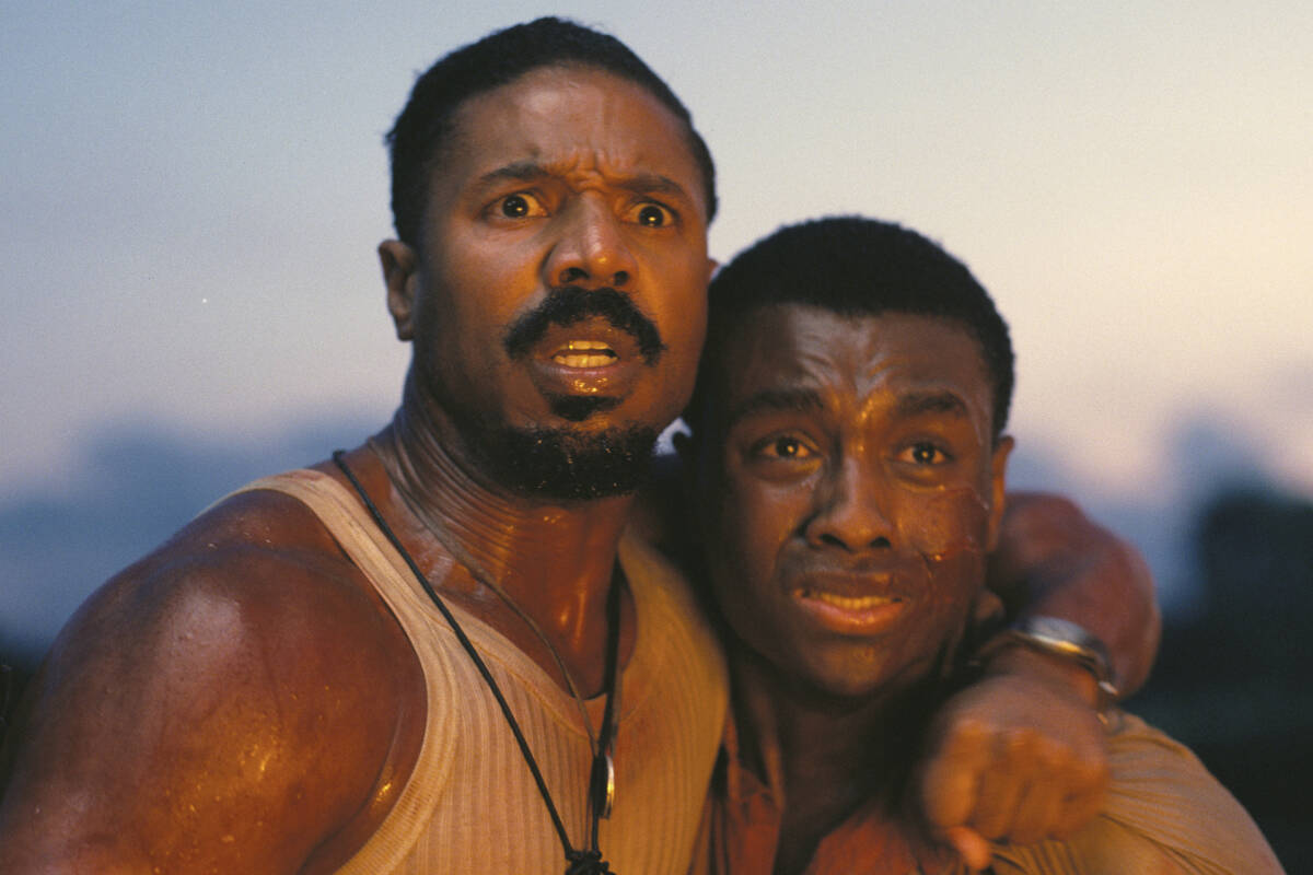 This image released by Warner Bros Pictures shows Michael B. Jordan, left, and Miles Caton in a ...
