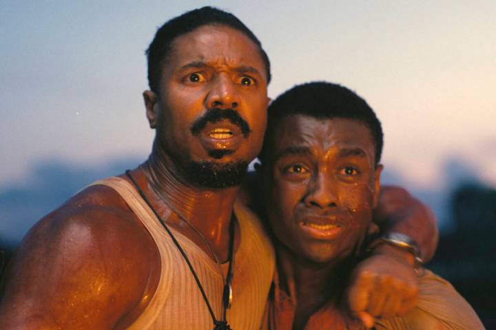 This image released by Warner Bros Pictures shows Michael B. Jordan, left, and Miles Caton in a ...