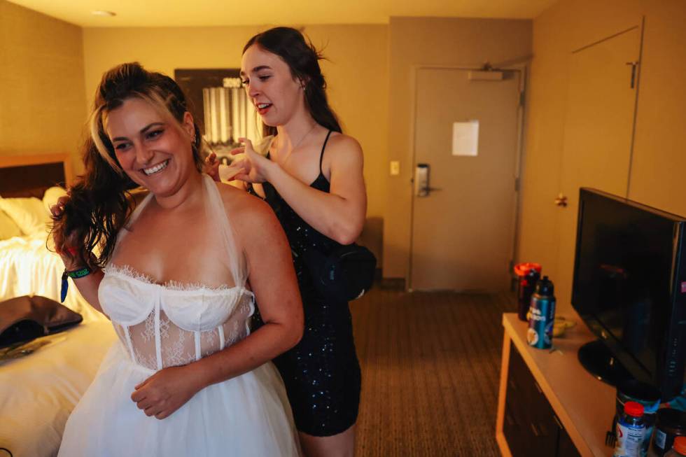 Shay Ray, front, gets her wedding dress tied up before participating in a “derby wedding ...