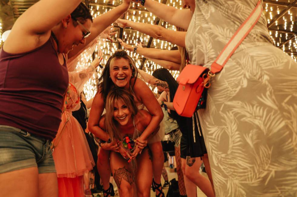 Kadee Strait, bottom, hoists up Shay Rae in a human tunnel after the RollerCon derby wedding ou ...
