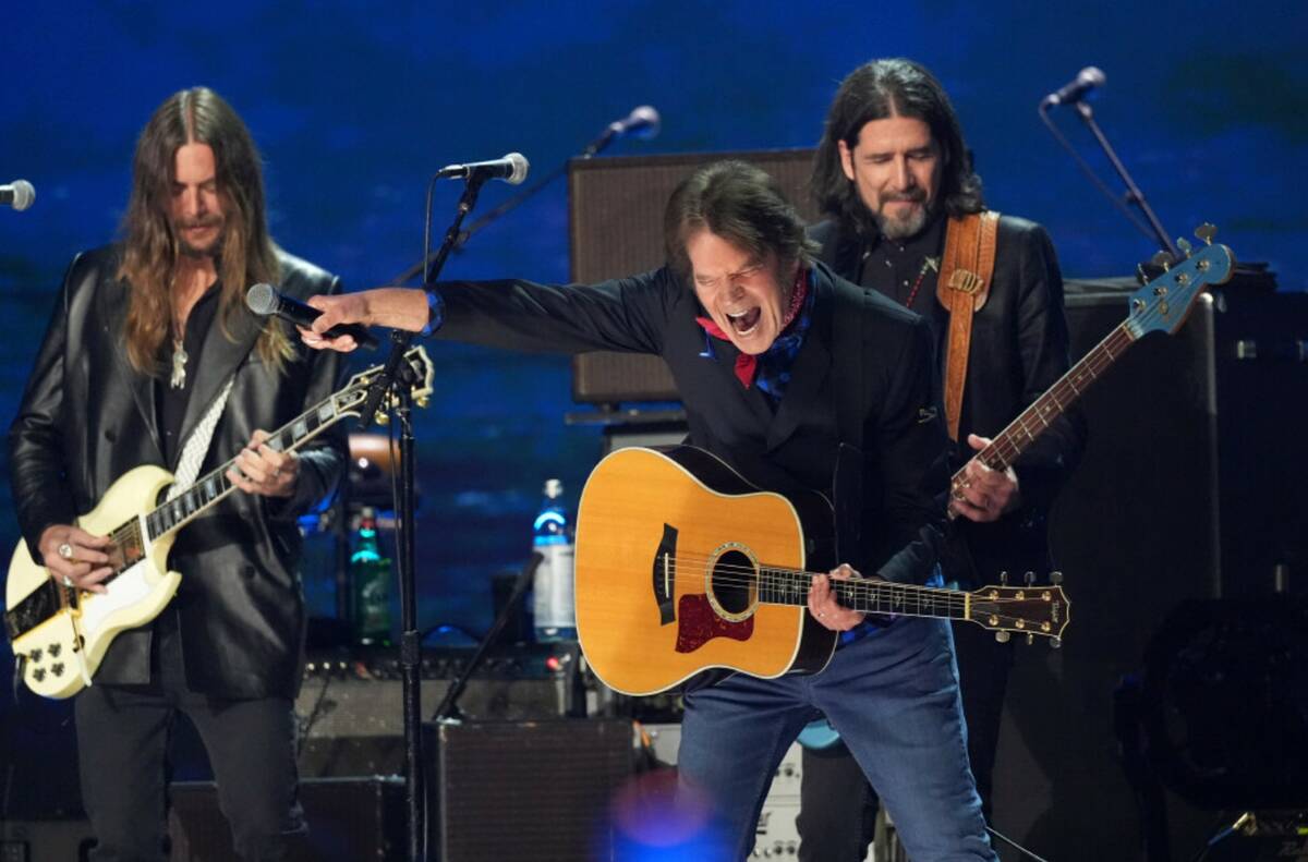 Nico Bereciartua, left, and Svien Pipien, right, of The Black Crowes perform with John Fogerty ...