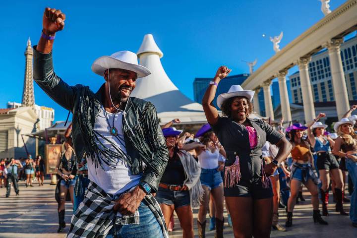 Fans dance to the music during a line dance to Beyonce’s “Texas Hold ‘Em” in front of C ...