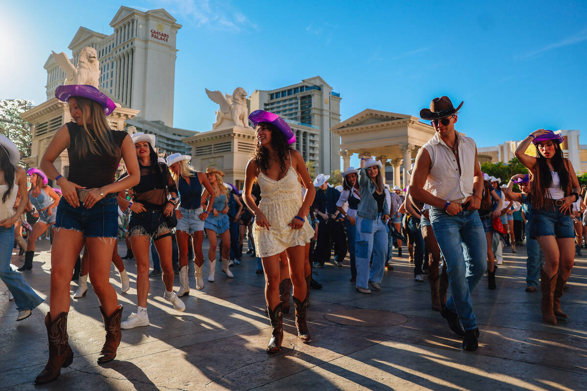 Fans dance to the music during a line dance to Beyonce’s “Texas Hold ‘Em&# ...