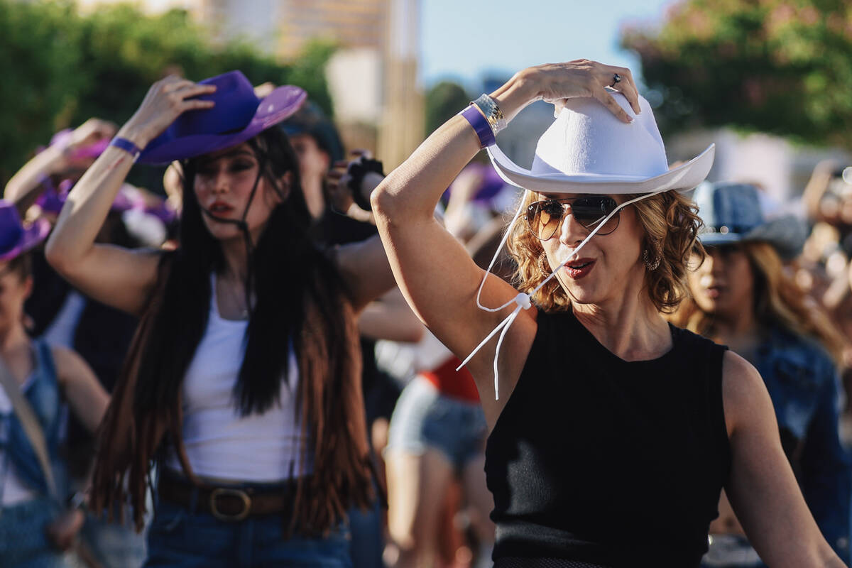 Fans dance to the music during a line dance to Beyonce’s “Texas Hold ‘Em&# ...