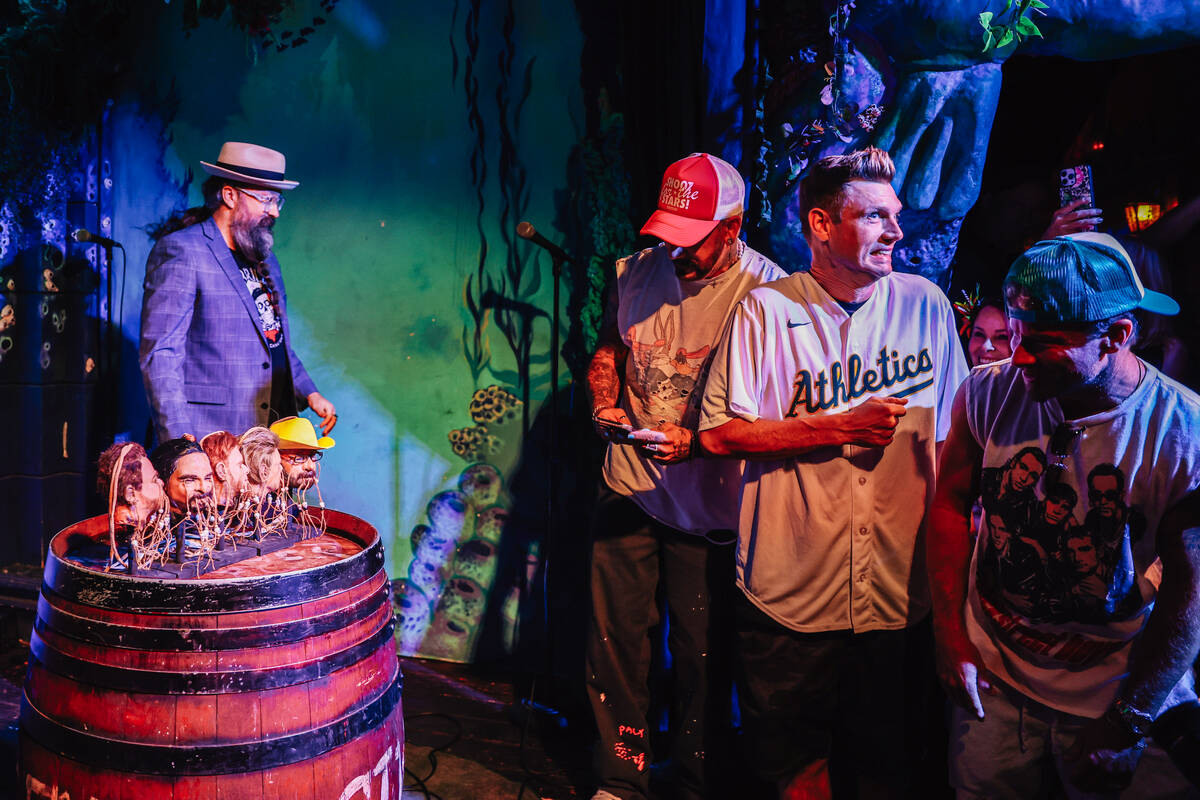 AJ McLean, from left, Nick Carter and Brian Littrell react as shrunken heads of themselves are ...