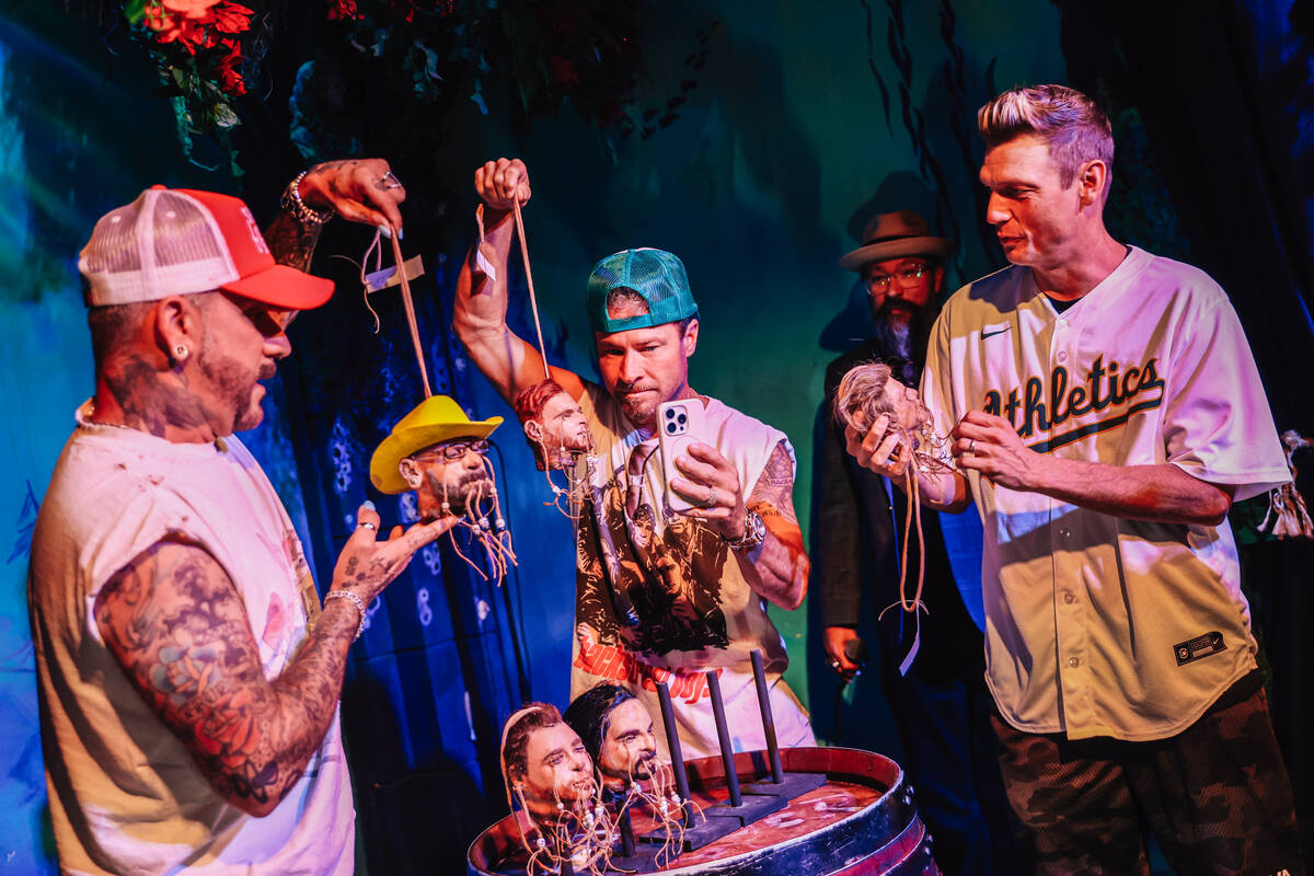 AJ McLean, from left, Brian Littrell and Nick Carter hold up shrunken head figures of themselve ...