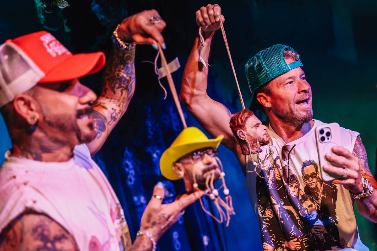 Backstreet Boys members AJ McLean, left, and Brian Littrell hold up shrunken head figures of th ...