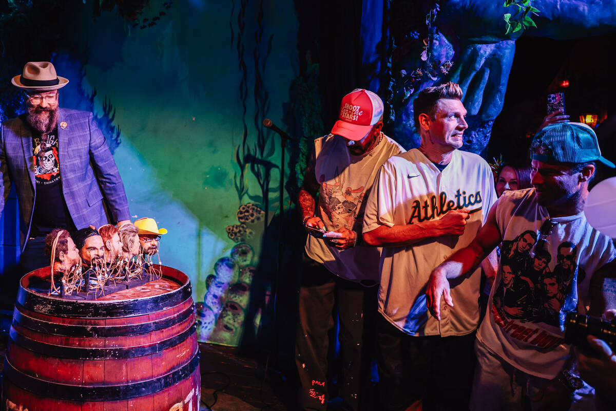 AJ McLean, from left, Nick Carter and Brian Littrell react as shrunken heads of themselves are ...