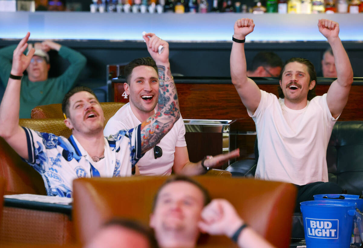 Ian Bullock, left, Andrew Massey and Ben Vietze, right, all of California, react on a play as t ...