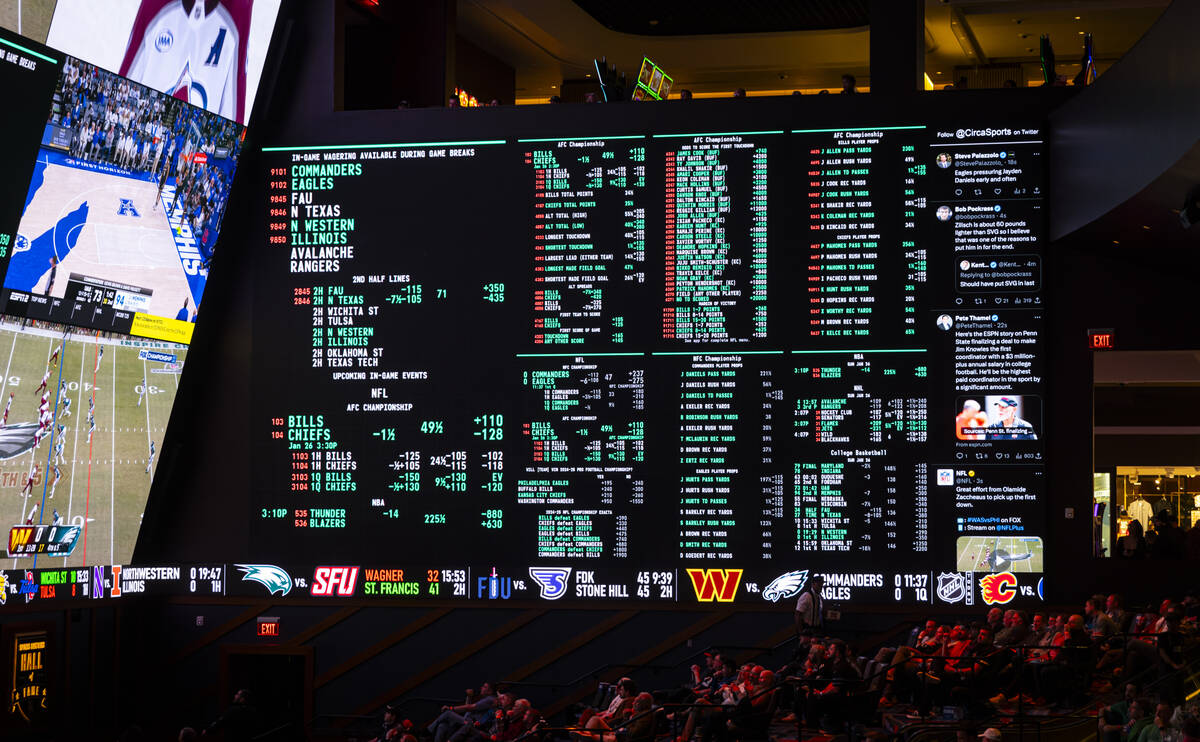 Betting lines are displayed as people watch the NFC championship football game at the Circa spo ...