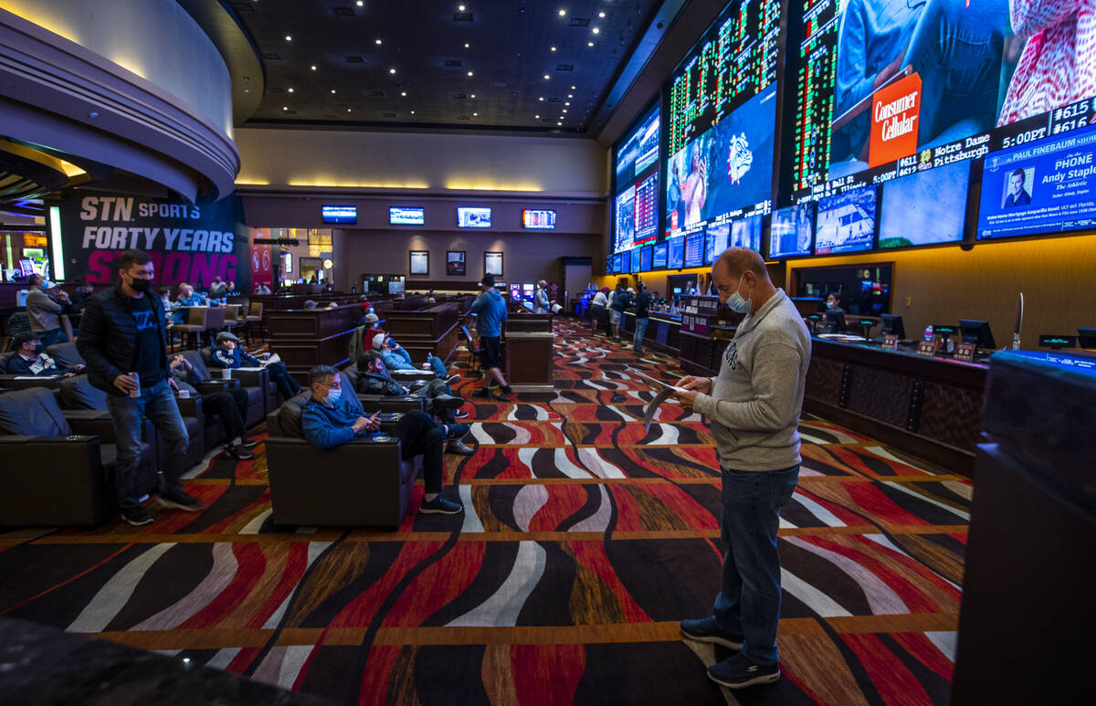 A guest looks to his betting sheet in the Sports Book at Red Rock Casino on Tuesday, Dec. 26, 2 ...
