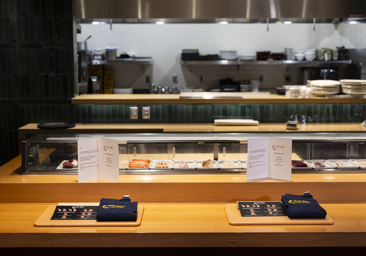 Place settings for the sushi-making class at Nobu, complete with a cutting board and apron, are ...