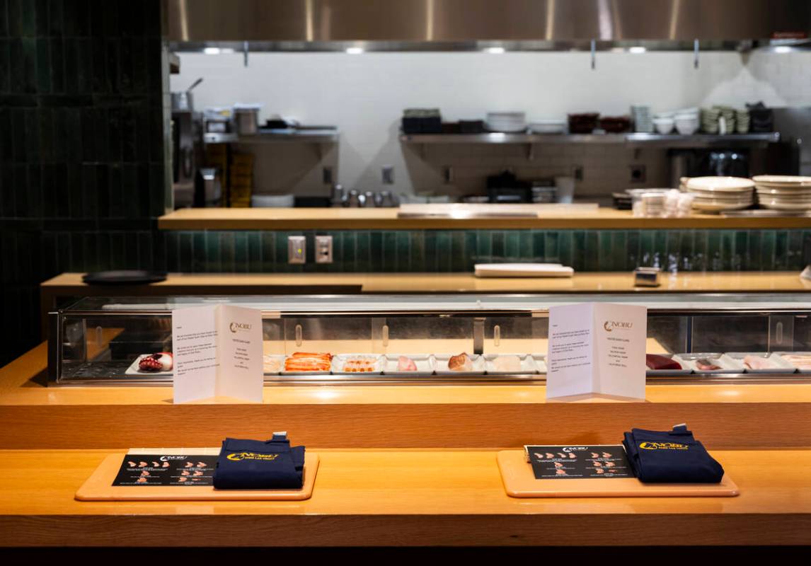 Place settings for the sushi-making class at Nobu, complete with a cutting board and apron, are ...