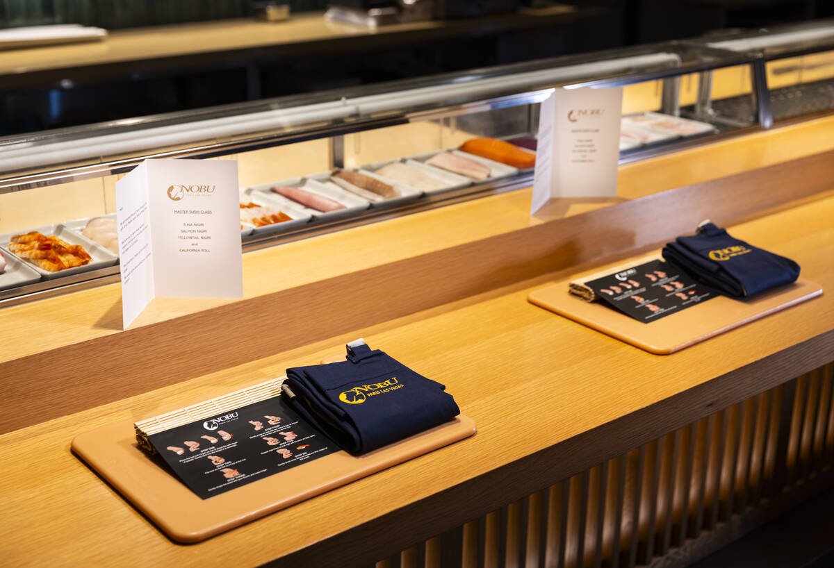 Place settings for the sushi-making class at Nobu, complete with a cutting board and apron, are ...