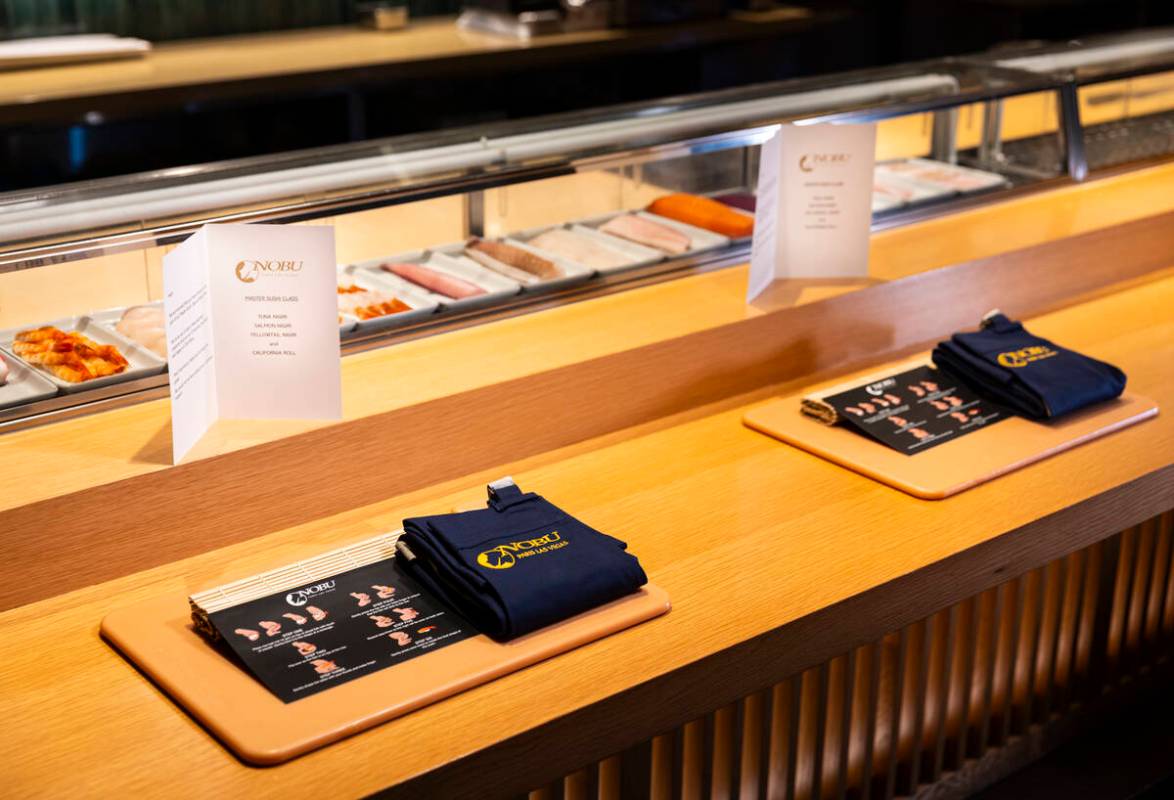 Place settings for the sushi-making class at Nobu, complete with a cutting board and apron, are ...