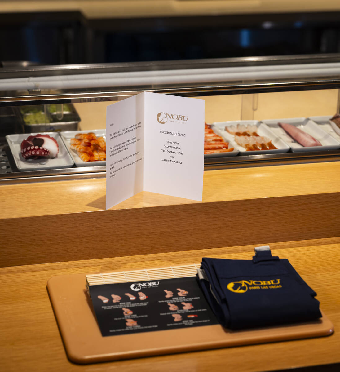 A place setting for the sushi-making class at Nobu, complete with a cutting board and apron, ar ...