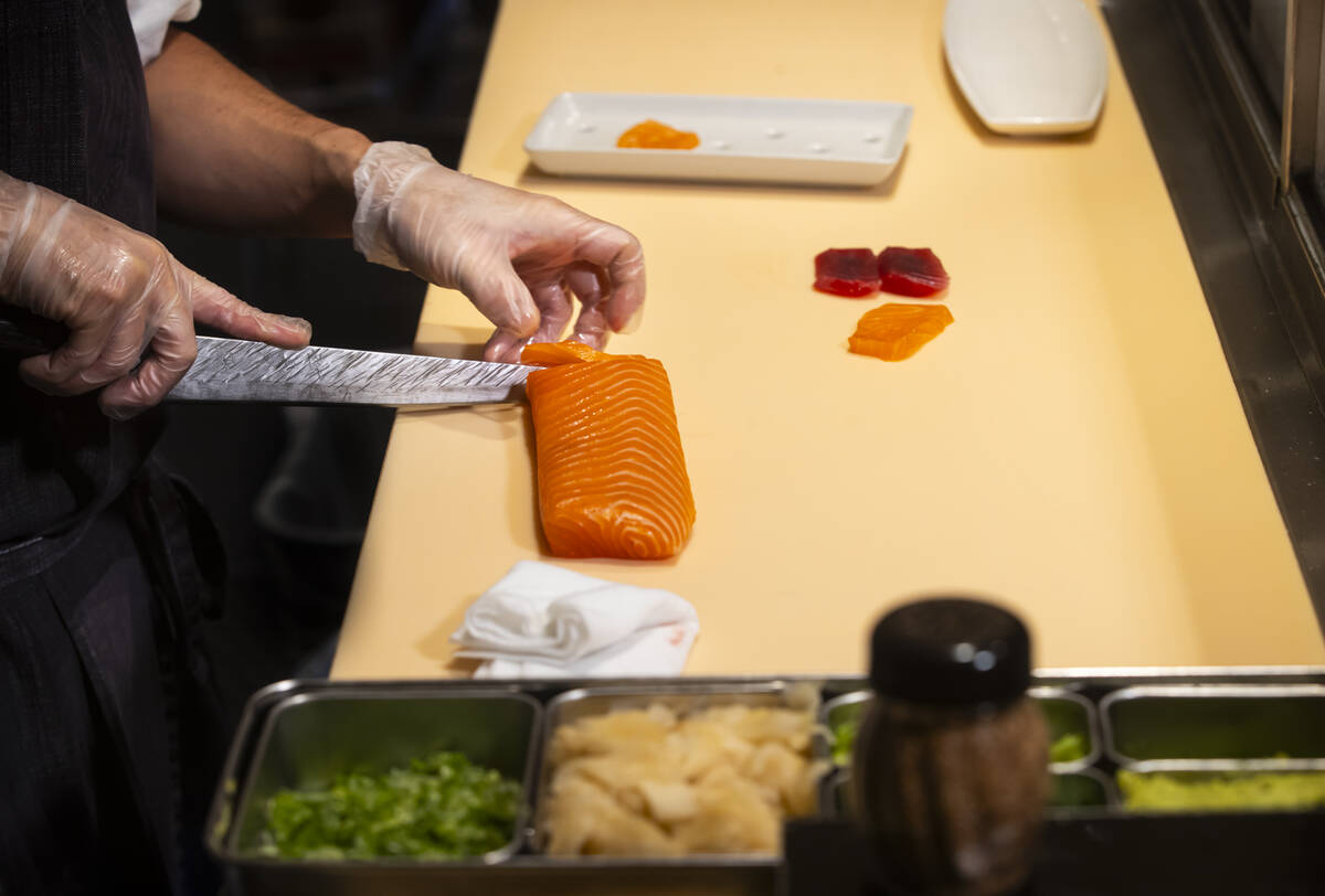 Tuan Pham, sous chef at Nobu, cuts salmon for nigiri in a sushi-making class demonstration at N ...