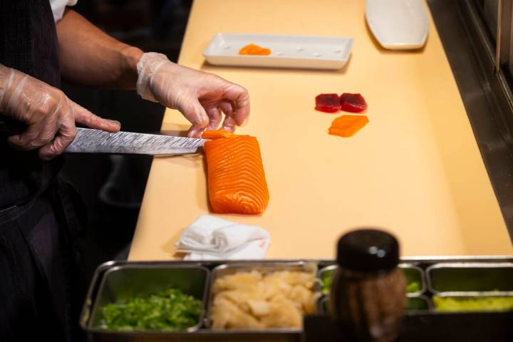 Tuan Pham, sous chef at Nobu, cuts salmon for nigiri in a sushi-making class demonstration at N ...