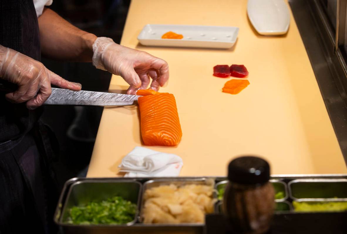 Tuan Pham, sous chef at Nobu, cuts salmon for nigiri in a sushi-making class demonstration at N ...