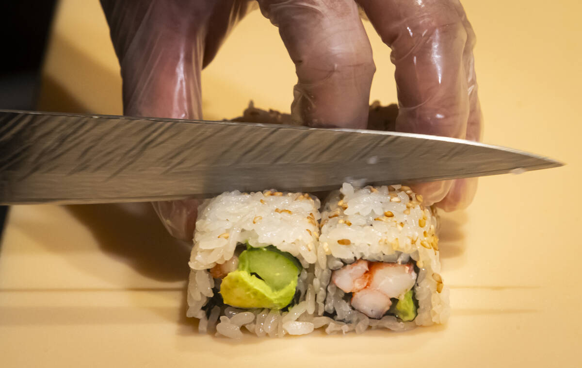 Tuan Pham, sous chef at Nobu, prepares a California roll for a sushi-making class demonstration ...