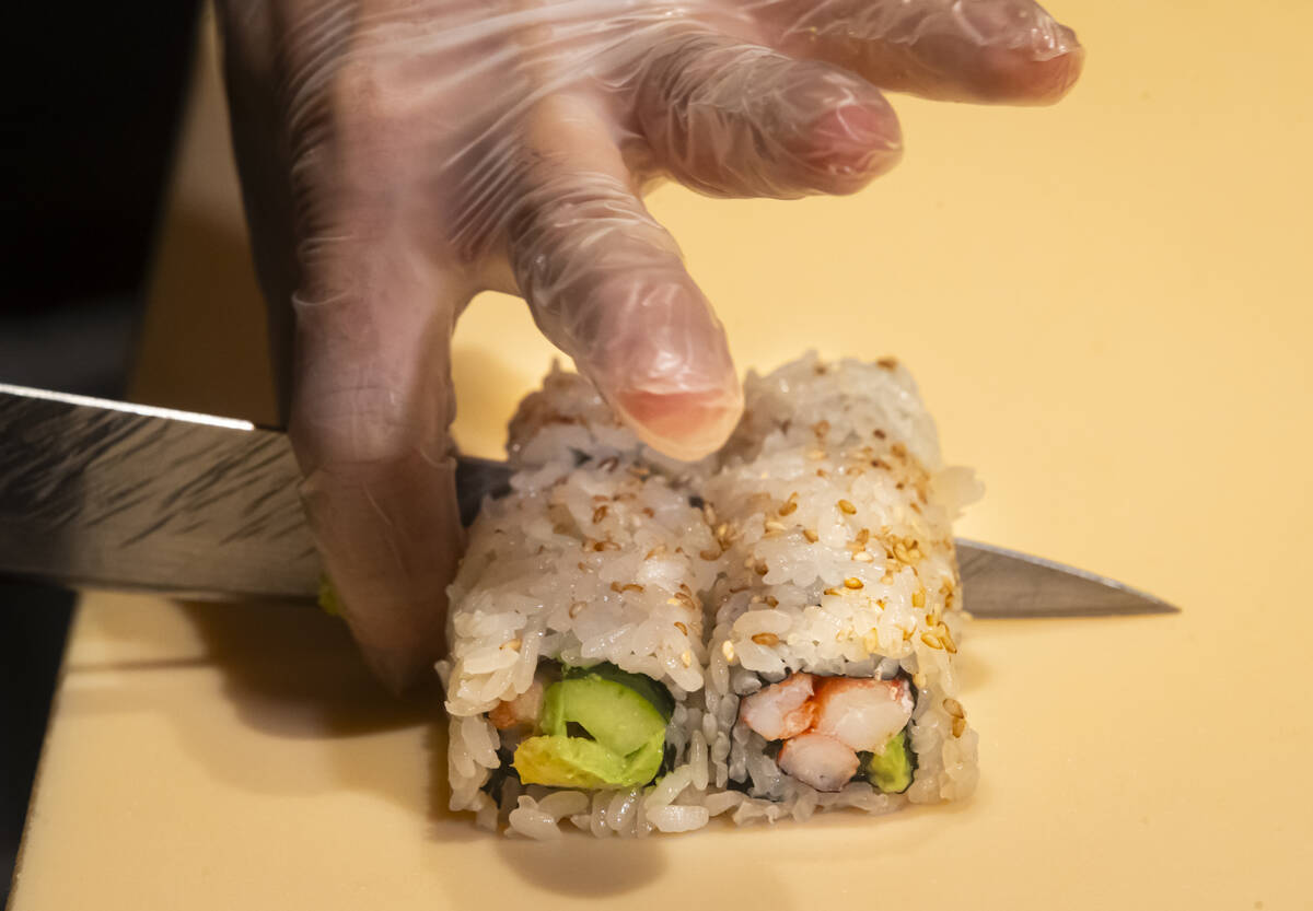 Tuan Pham, sous chef at Nobu, prepares a California roll for a sushi-making class demonstration ...