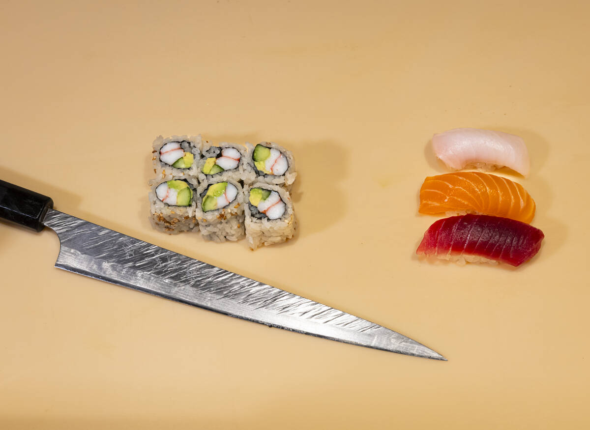 Tuan Pham, sous chef at Nobu, out of frame, prepares a California roll and nigiri for a sushi-m ...