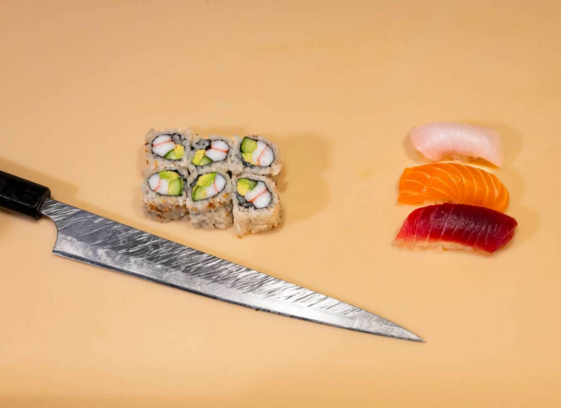 Tuan Pham, sous chef at Nobu, out of frame, prepares a California roll and nigiri for a sushi-m ...