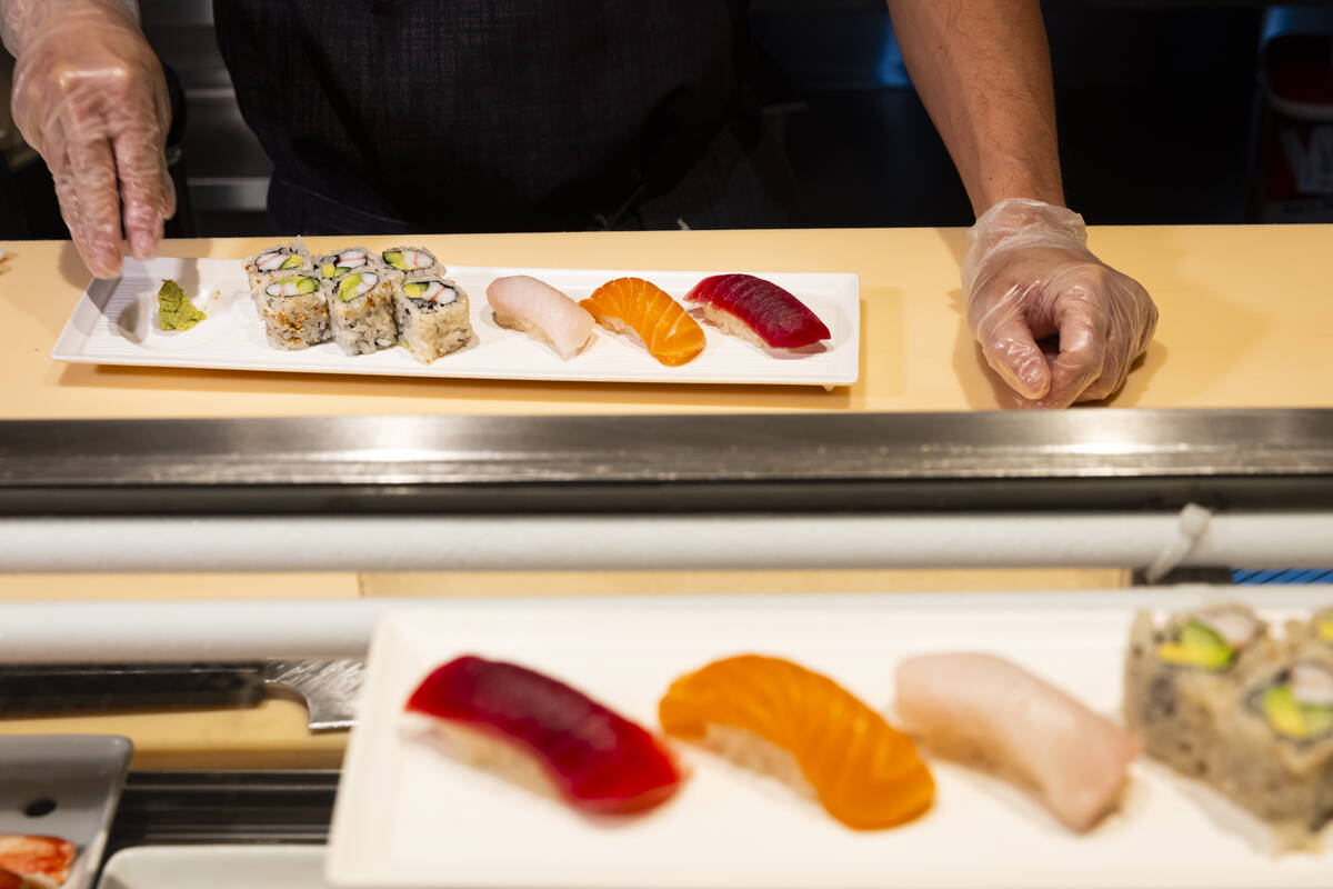 Tuan Pham, sous chef at Nobu, plates a California roll and nigiri for a sushi-making class demo ...