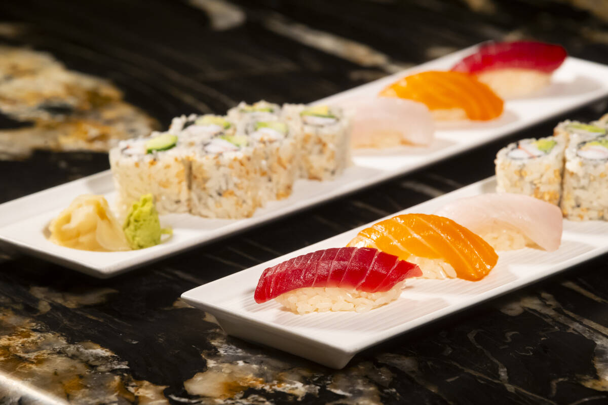 Tuna, salmon and yellowtail nigiri is seen alongside a California roll, prepared by Nobu sous c ...