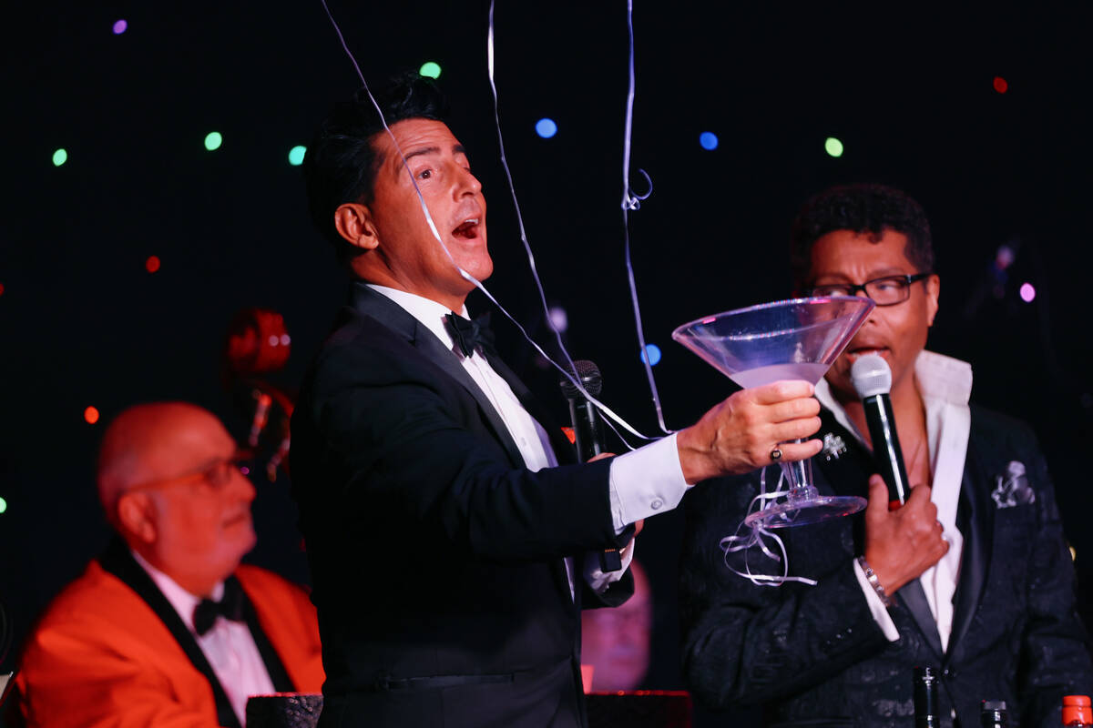Drew Anthony enters the stage as Dean Martin, carrying an oversized martini glass during The Ra ...