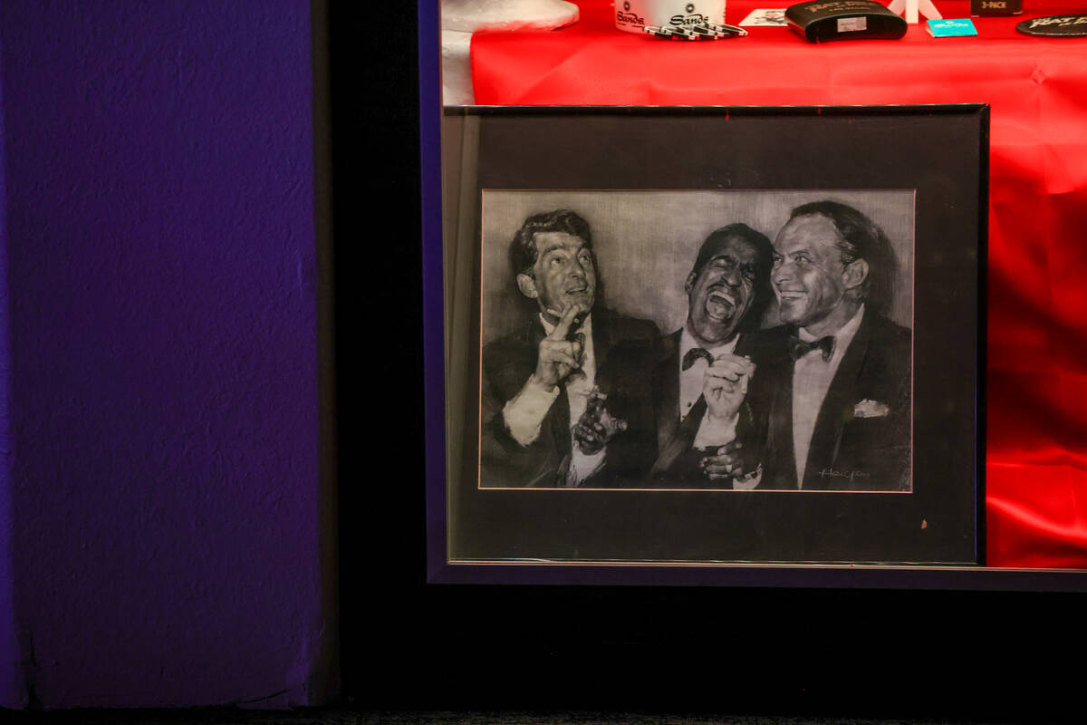 A vintage print of Dean Martin, Sammy Davis Jr. and Frank Sinatra laughing sits on display at t ...