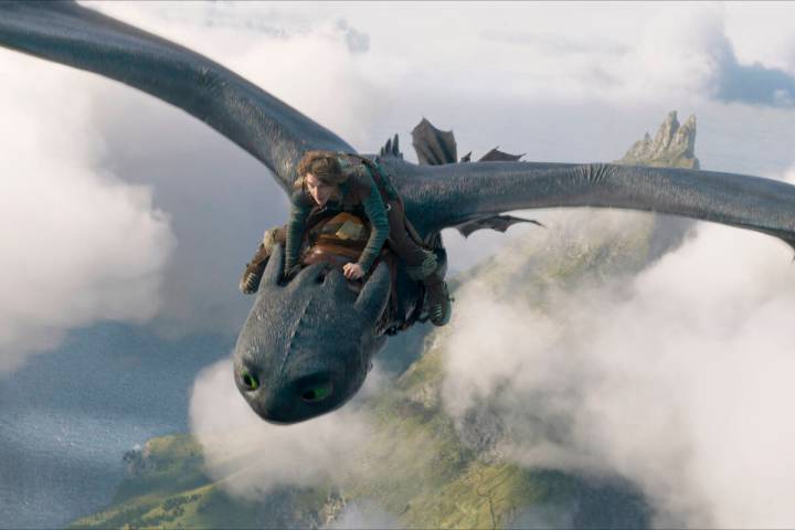 This image released by Universal Pictures shows Mason Thames, as Hiccup, riding Night Fury drag ...