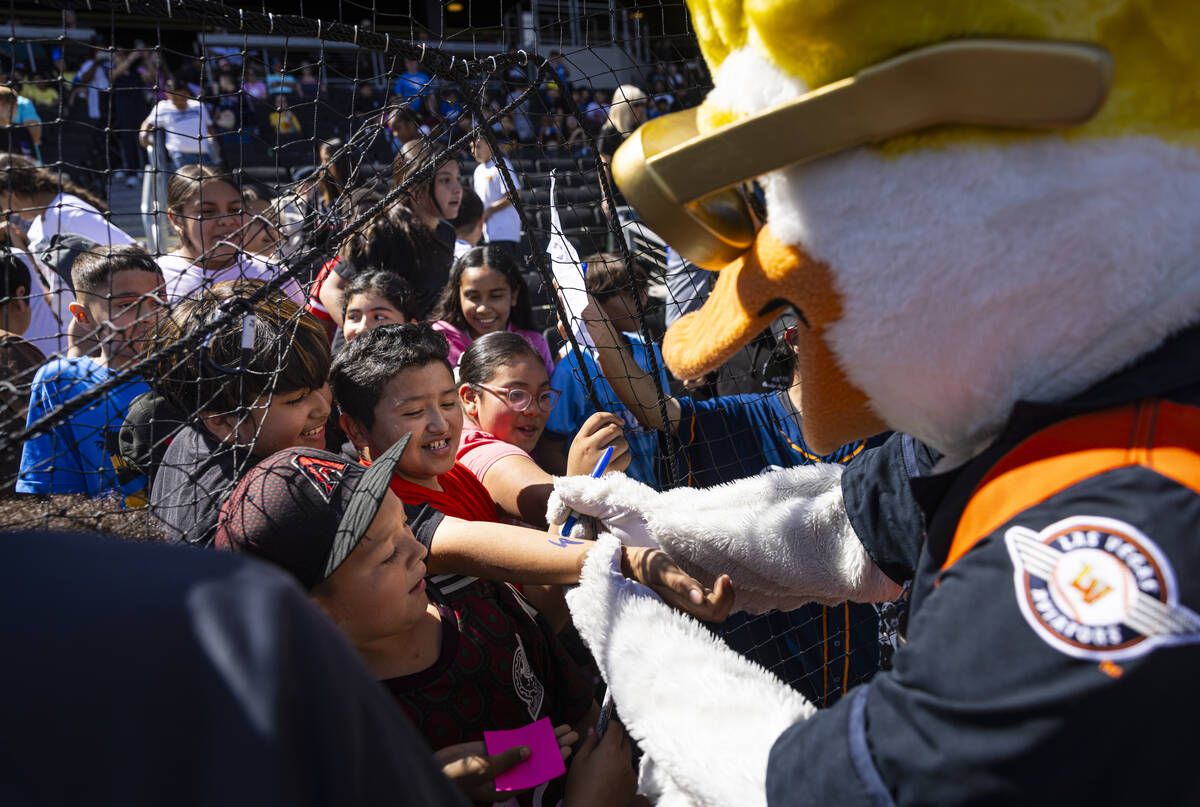 Aviators mascot Spruce the Goose signs autographs for young attendees before a Triple-A basebal ...