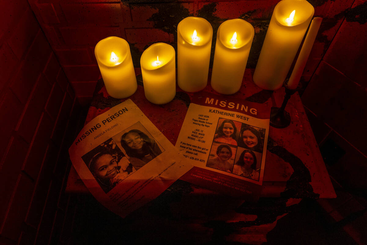 Missing posters of two girls are lit by candles in a scene from Blumhouse's The Exorcist: Belie ...