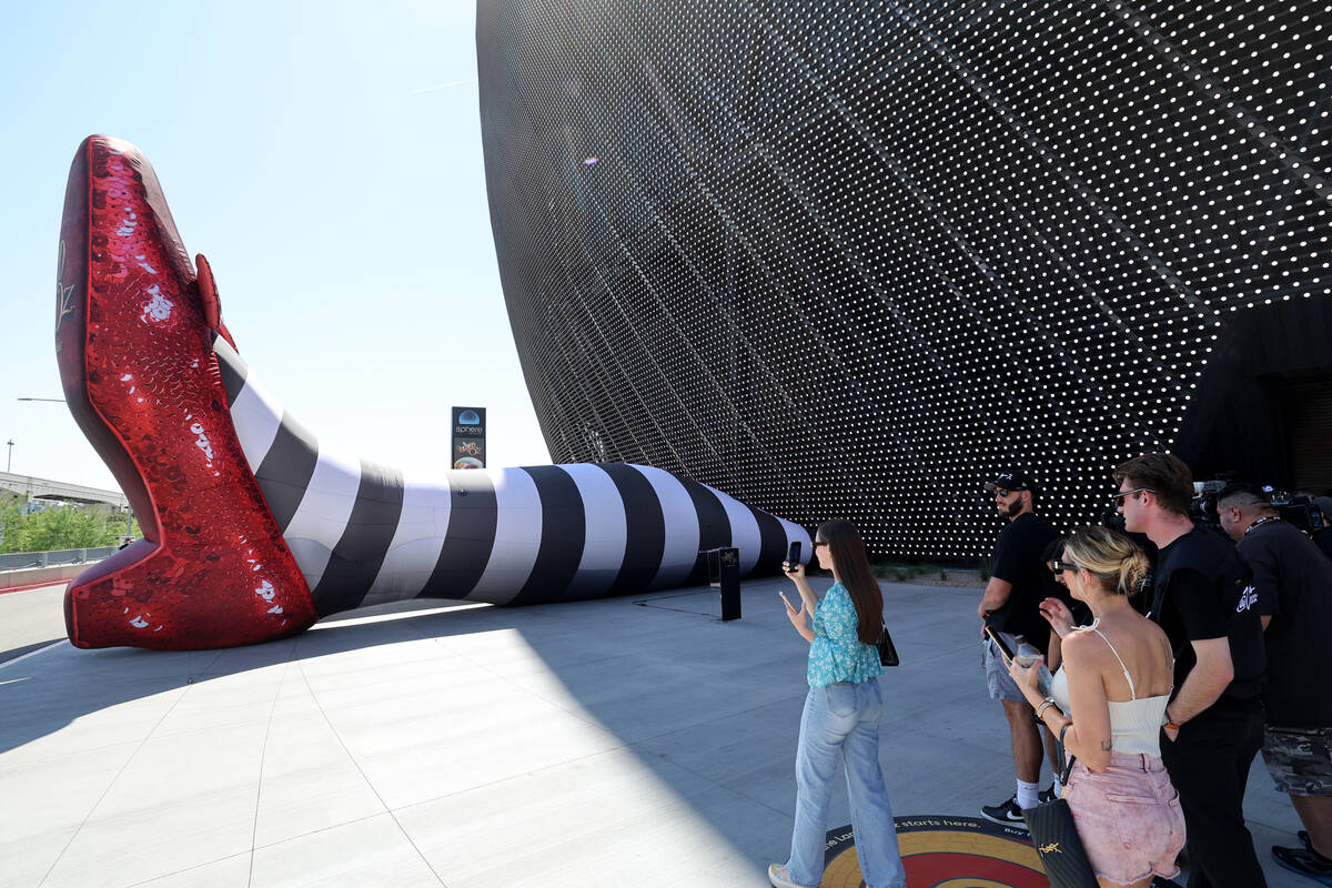 People check out the Wicked Witch of the East legs and ruby slippers installation promoting &qu ...