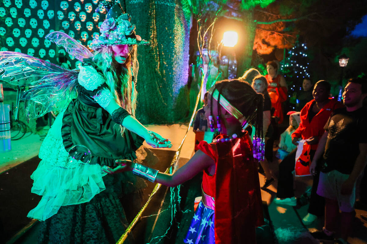 Angela Brunson, known as “Joy the Bubble Fairy,” hands out candy to children duri ...