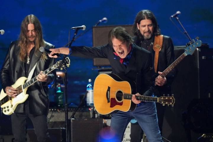 Nico Bereciartua, left, and Svien Pipien, right, of The Black Crowes perform with John Fogerty ...