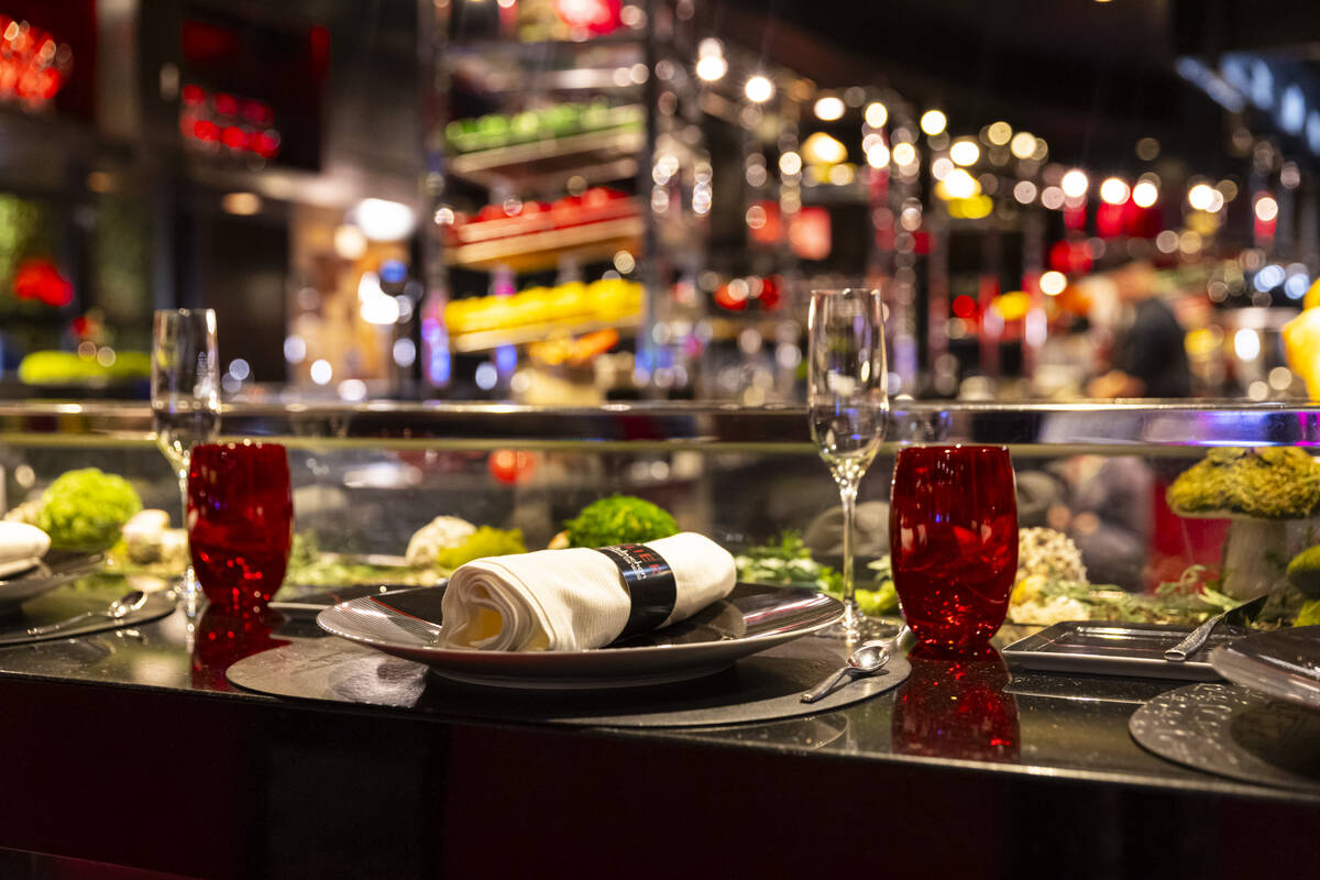Table settings at the counter, which offers a view of the open kitchen, at L'Atelier de Joël R ...