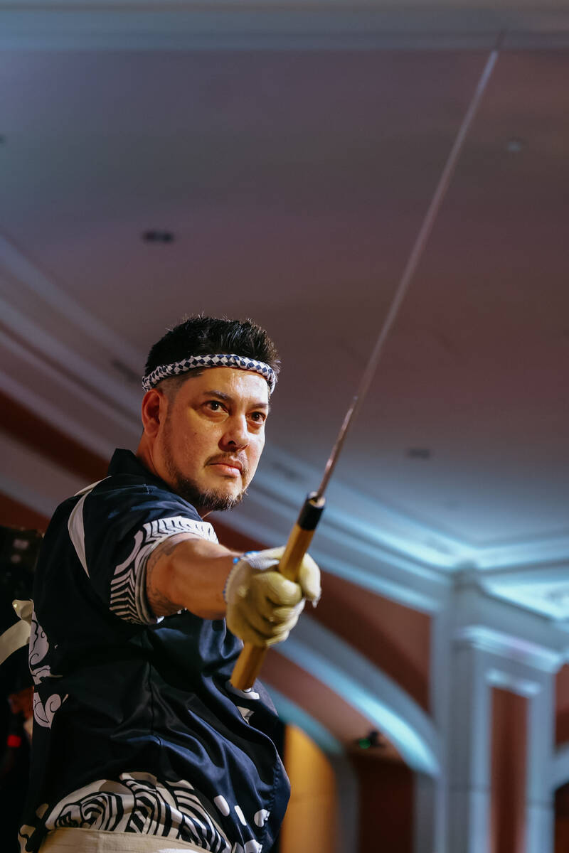 Chef Jeff Ramsey, from Mizumi, brandishes a large knife to carve an over 200-pound tuna in fron ...