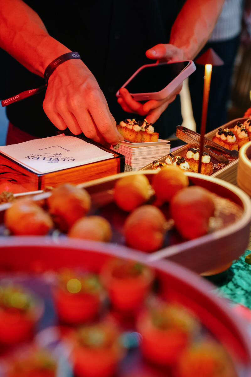 A guest scoops up a pair of king crab and saffron tartlets, with saffron lebneh cream, citrus, ...