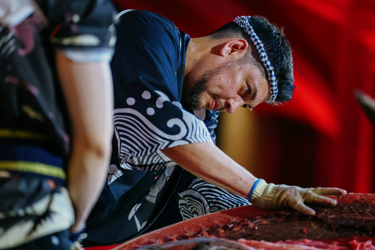 Chef Jeff Ramsey, of Mizumi, carves an over 200-pound tuna for a crowd during Revelry’s ...