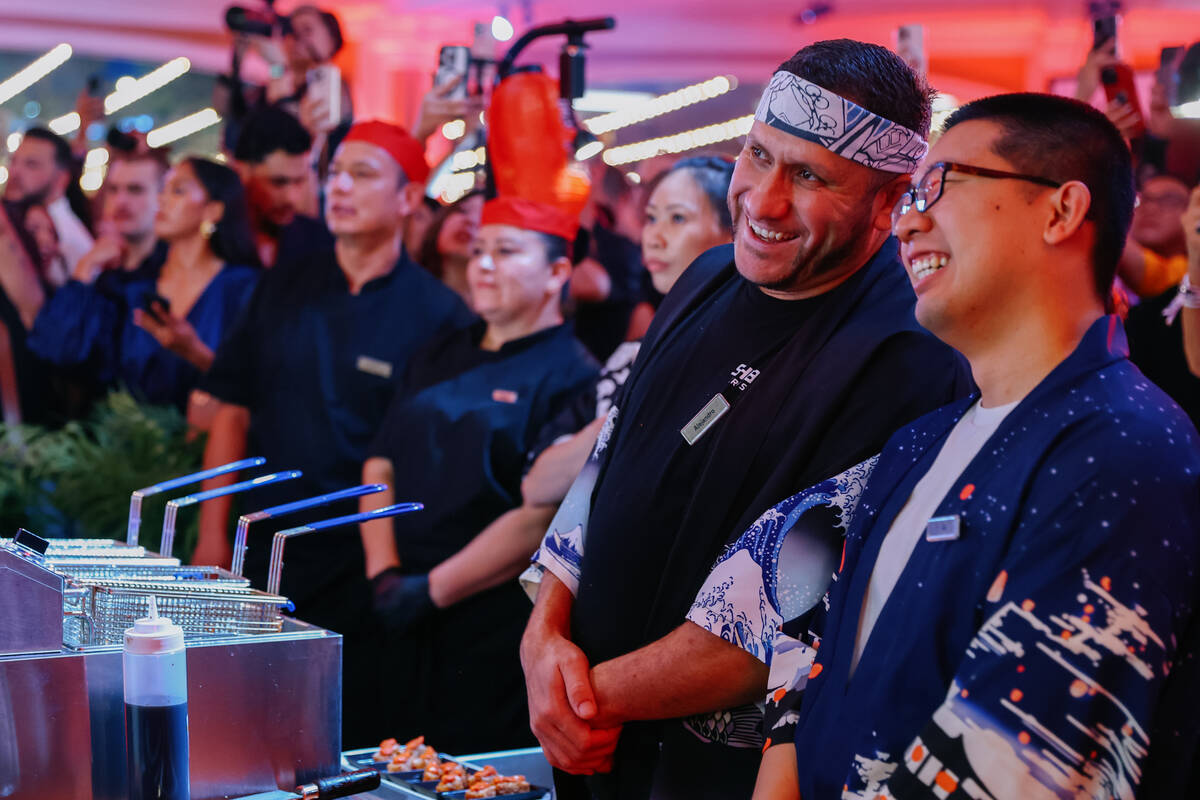 A crowd watches as Chef Jeff Ramsey, from Mizumi, carves an over 200-pound tuna during Revelry& ...