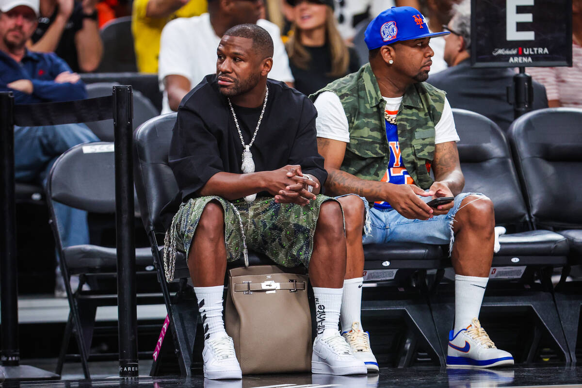 Floyd Mayweather, left, watches game action during a WNBA basketball game between the Aces and ...